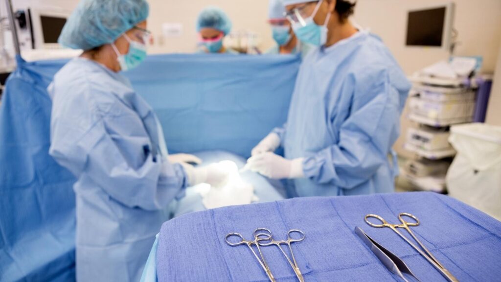 Allied health technicians working at a surgical table.