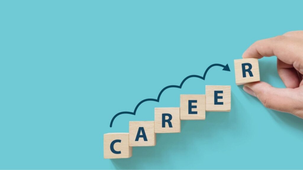 Hand placing blocks spelling out "CAREER" on a turquoise background.