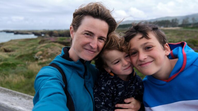 Single travel nurse mom taking a photo in the outdoors with her two kids.