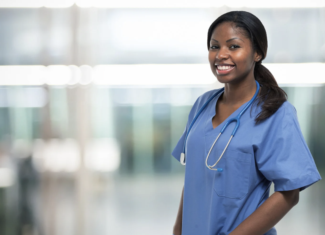 healthcare professional smiles into camera on travel nurse assignments